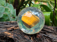 Polished Tigers Eye cobbed piece in PVC Resin Sphere - sold per item - From Northern Cape, South Africa